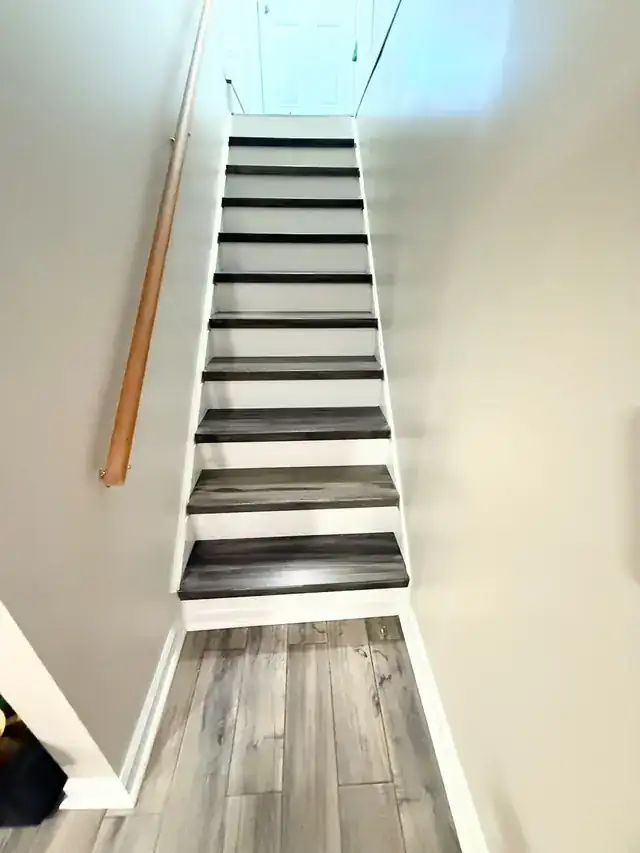 Narrow staircase with white painted risers and dark treads