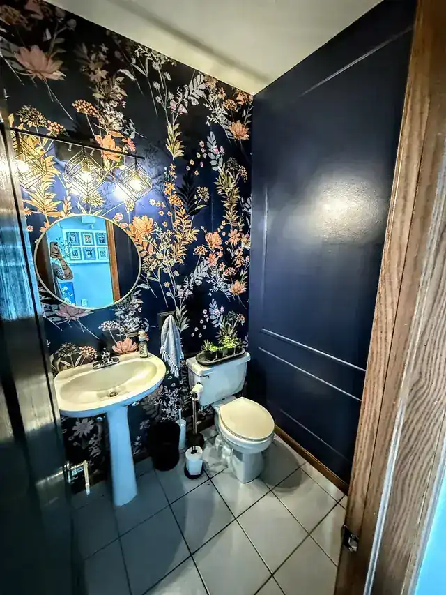 Powder room with navy floral wallpaper and a deep navy painted door