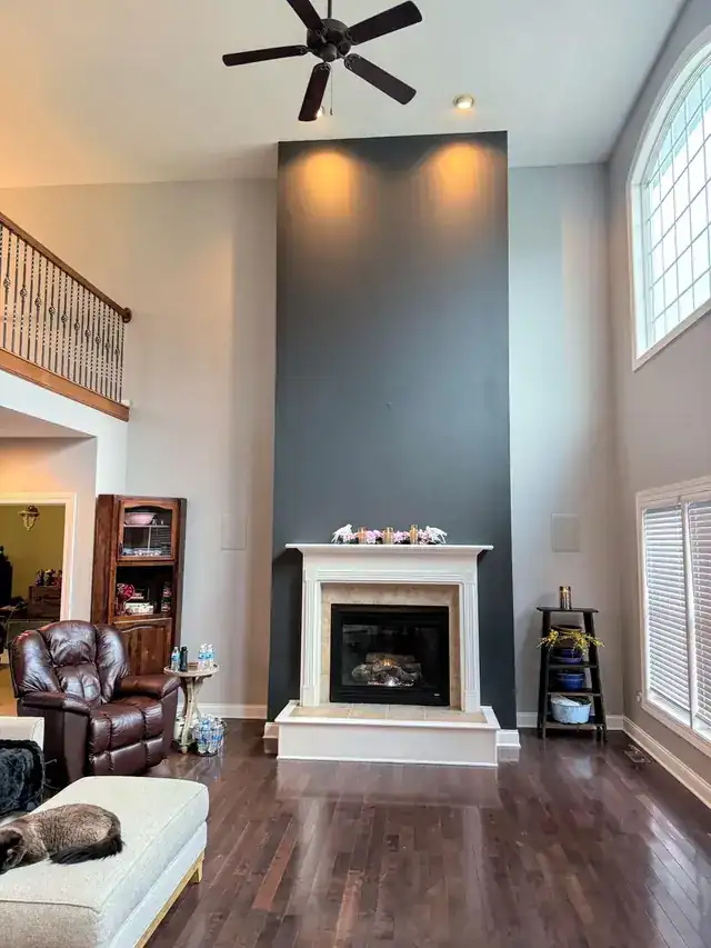 Tall charcoal-slate chimney wall above a white fireplace