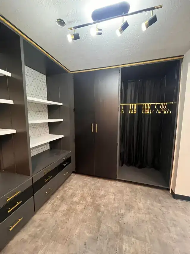 Built-in storage painted near-black with gold pulls