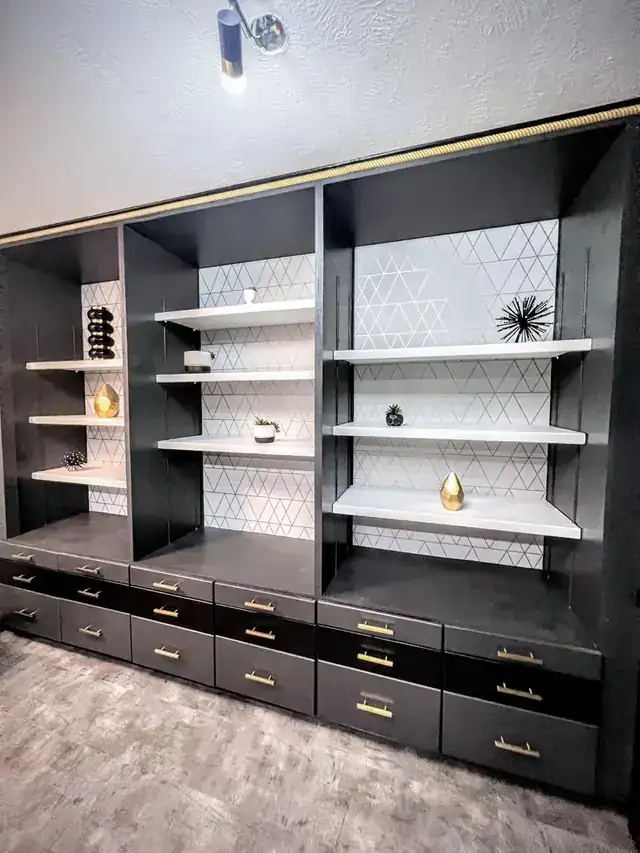 Dark built-in shelving with gold pulls