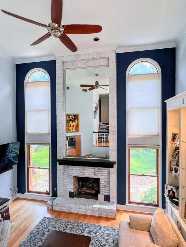 Great room with navy painted panels framing tall arched windows