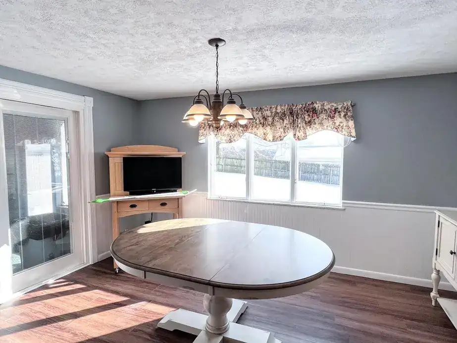 Dining nook with grey walls above white wainscot