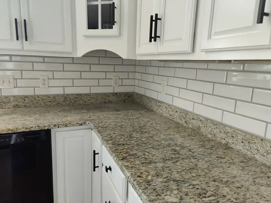 White subway tile backsplash over a granite counter