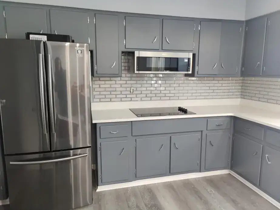 Grey painted kitchen cabinets with a white subway tile backsplash