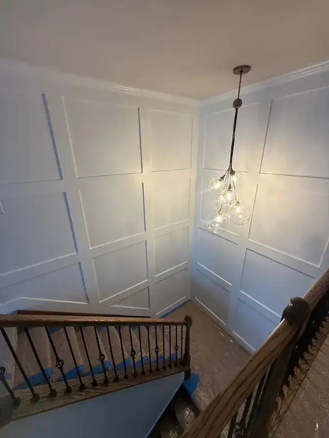 Stairwell wall with applied panel molding painted white